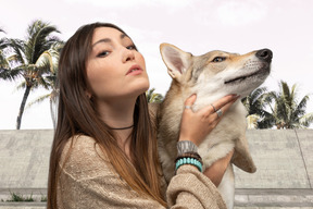 彼女の犬と一緒にポーズをとる女性