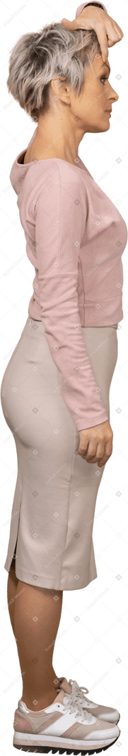 Vista laterale di una donna in abiti casual che tocca il sopracciglio con un dito