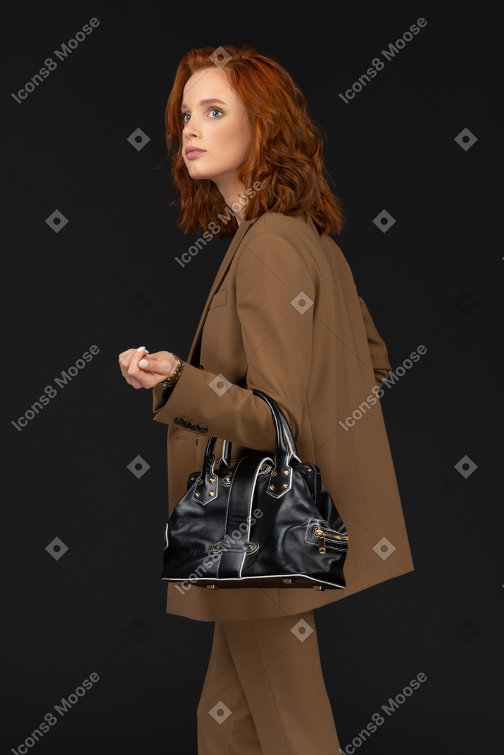 Side view of a young businesswoman with handbag