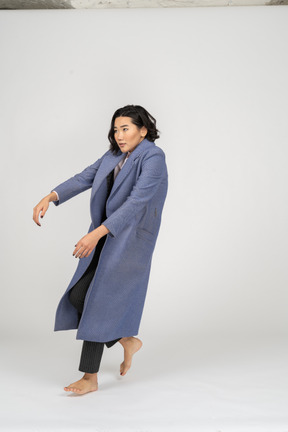 Woman in coat falling backwards