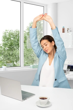 A woman stretching her arms in an office