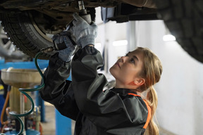 Young woman repairing car