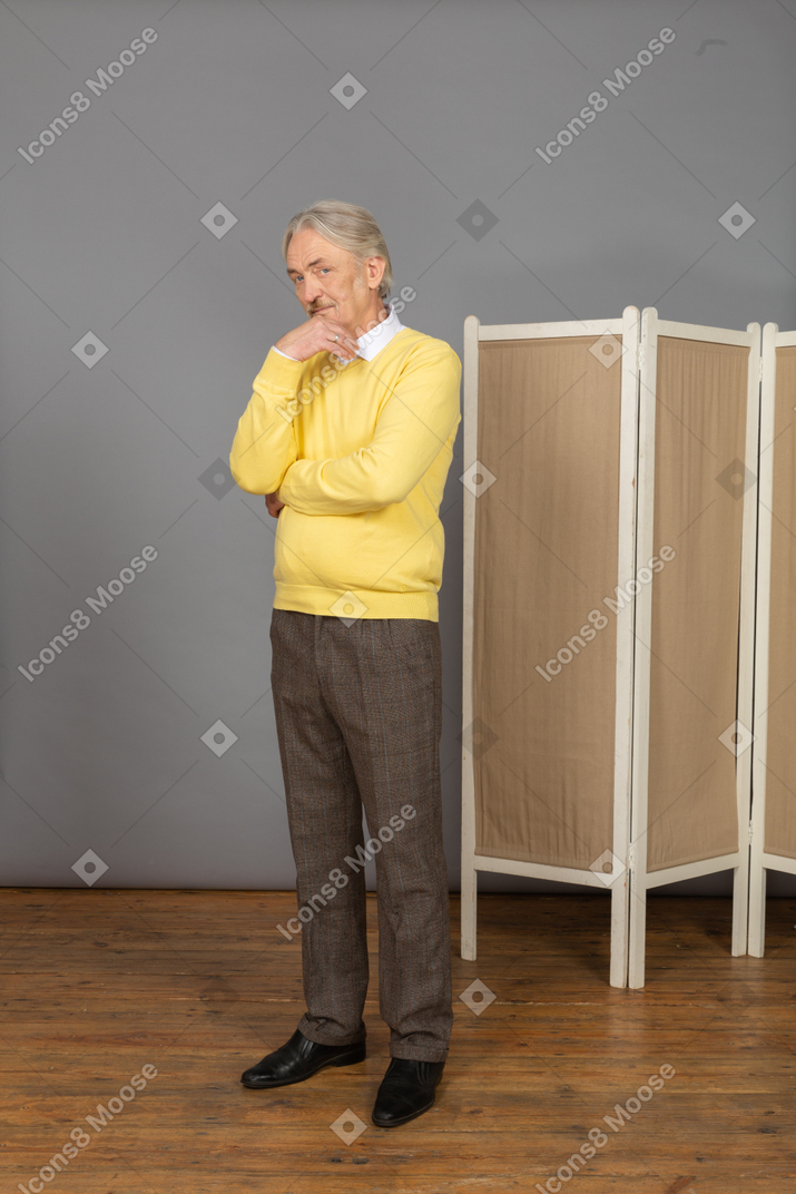 Three-quarter view of thoughtful old man touching chin