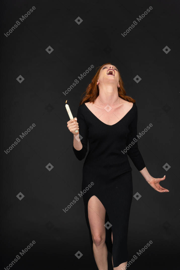 A frontal view of a sexy beautiful girl standing on the dark background and screaming
