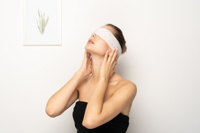 Femme avec un bandage sur les yeux inclinant la tête en arrière