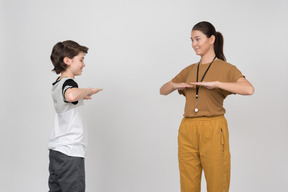 Pe female teacher and pupil exercising