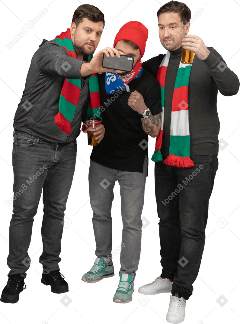 Vista frontale di tre tifosi di calcio di sesso maschile che prendono selfie