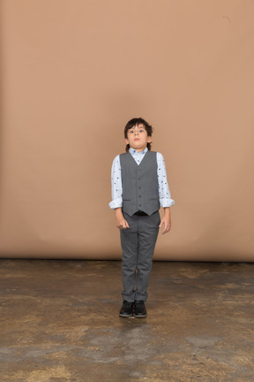 Front view of a scared boy in suit looking at camera