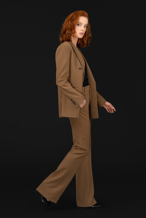 A woman in a brown suit and black shoes
