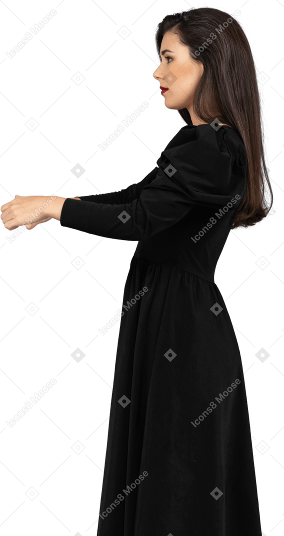 Seitenansicht einer jungen dame in einem schwarzen kleid, das hände ausstreckt