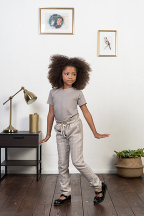 Good looking girl kid posing on the apartment background