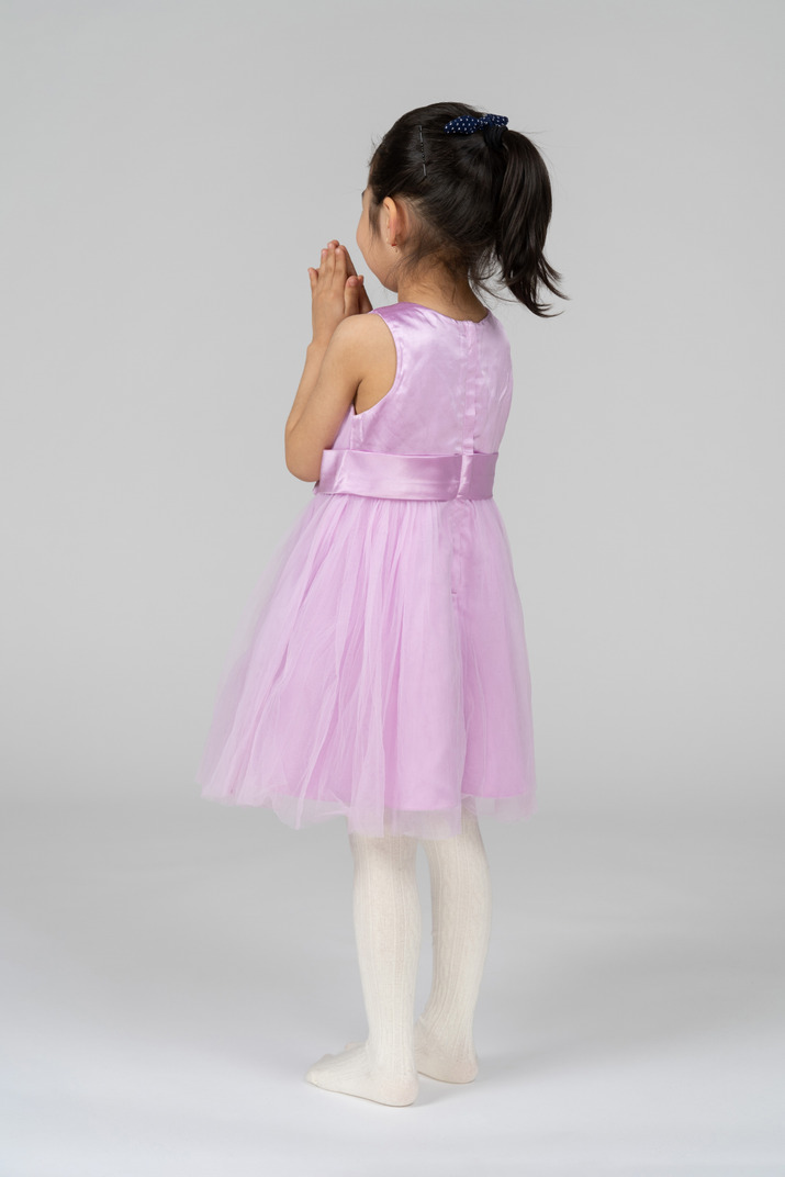Girl in pink dress with her hands folded