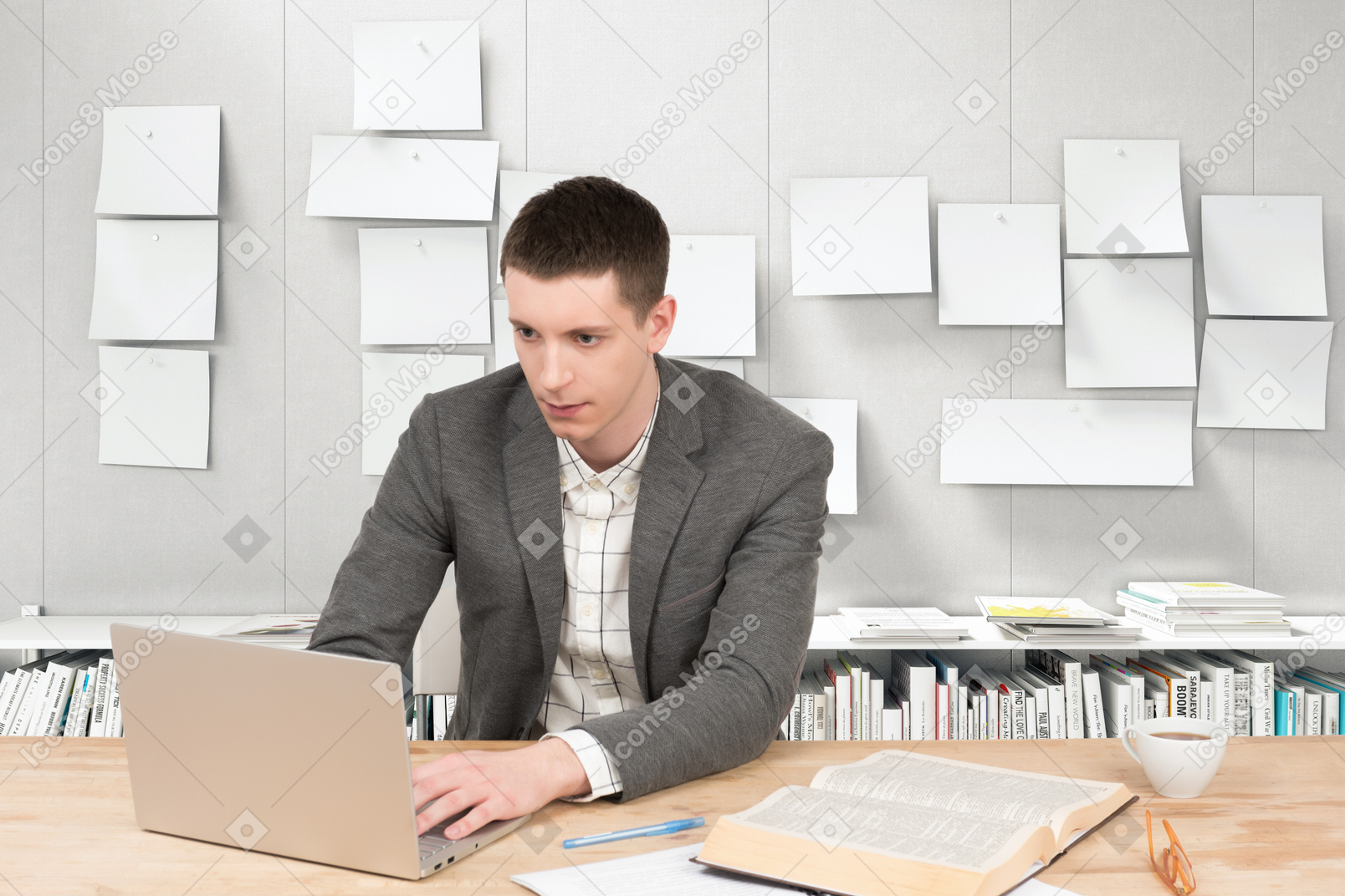 一个男人坐在一张桌子和一台笔记本电脑