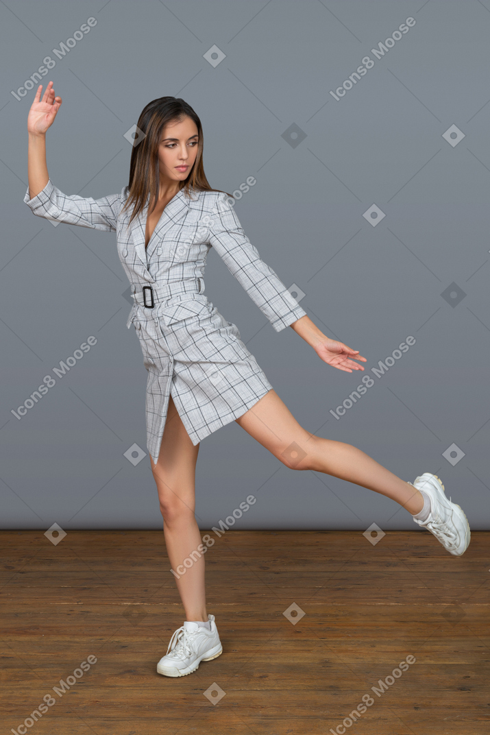 Serious young woman balancing on one leg