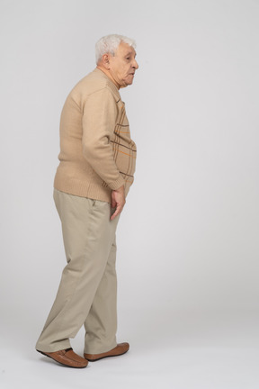 一位穿着休闲服走路的老人的侧视图