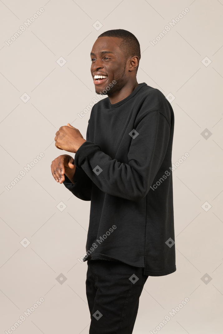 Laughing young man in black clothes gesturing