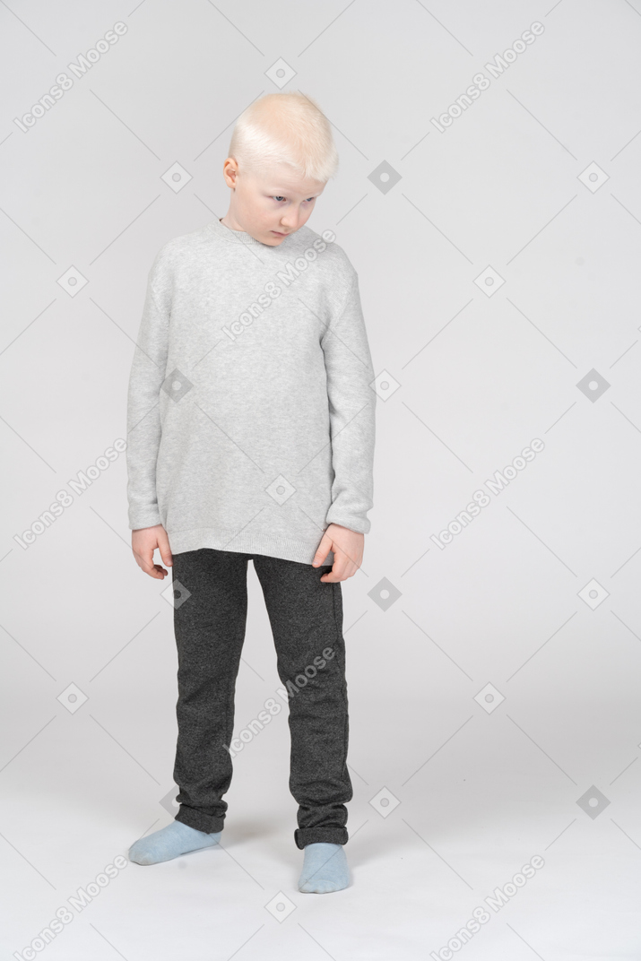 Front view of a shy little boy in casual clothes