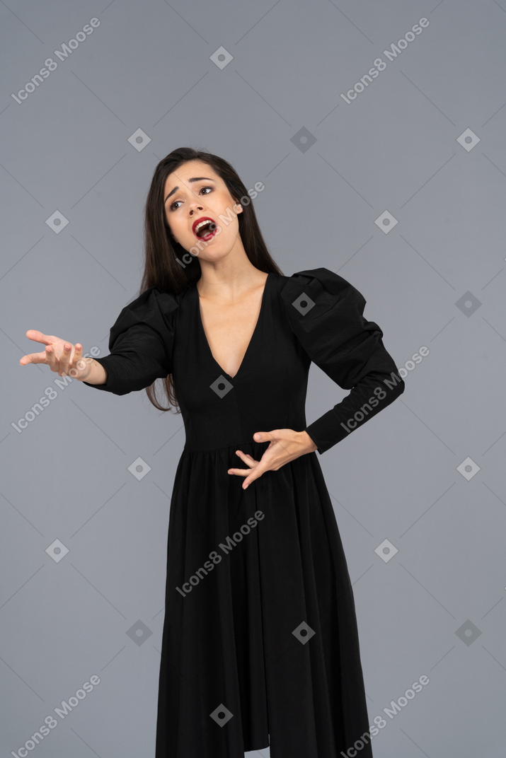 打手势歌剧女歌手穿着黑色连衣裙的前视图