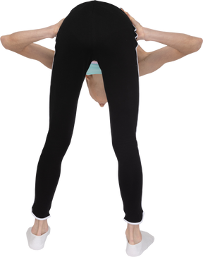 Vista posterior de una jovencita en ropa deportiva poniendo las manos en las caderas mientras se inclina hacia adelante