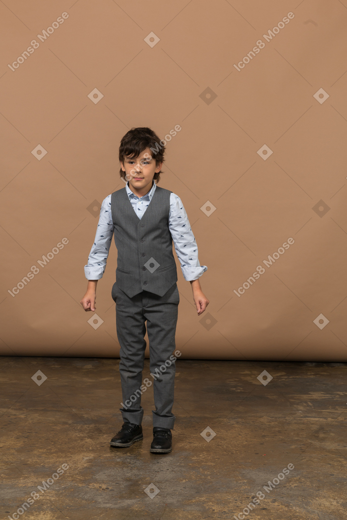 Vorderansicht eines jungen im grauen anzug, der in die kamera schaut