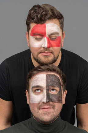 Front view of two male football fans with face art