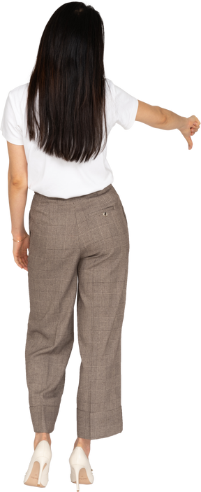 Vista traseira de uma jovem senhora de calça e camiseta mostrando o polegar para baixo
