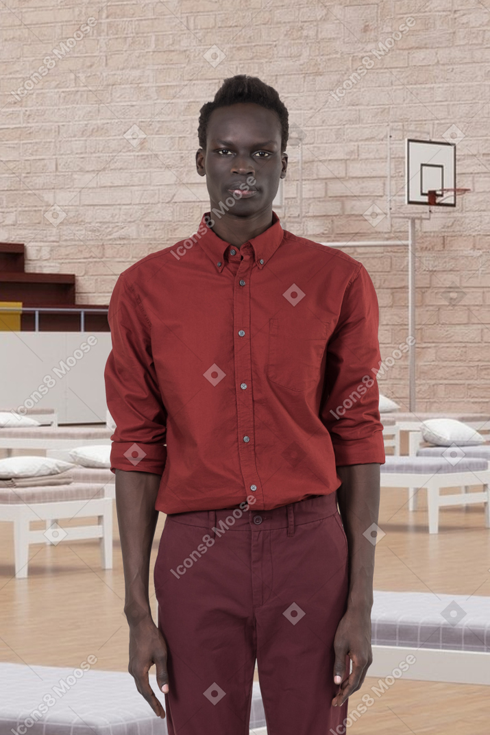 Man standing in a basketball court with beds
