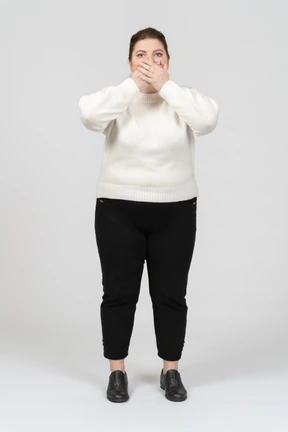 Plus size woman in casual clothes closing mouth with hands
