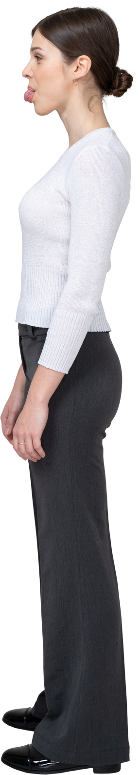 Side view of a young woman in office clothing showing tongue