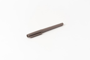 Stylo marron sur fond blanc