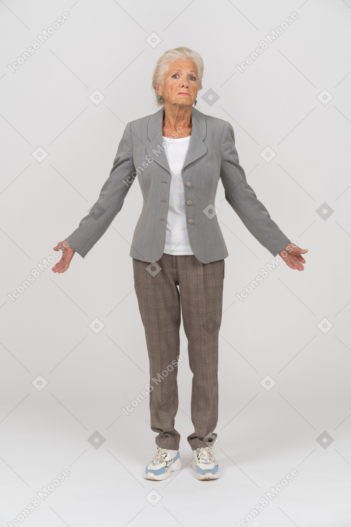 一位身着西装的老妇人的前视图，看着相机，打着手势