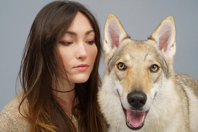 両方のカメラを見ている彼女の犬と女性のマスターのクローズアップ