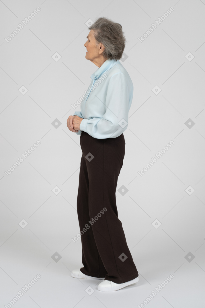Vista lateral de una anciana con las manos entrelazadas