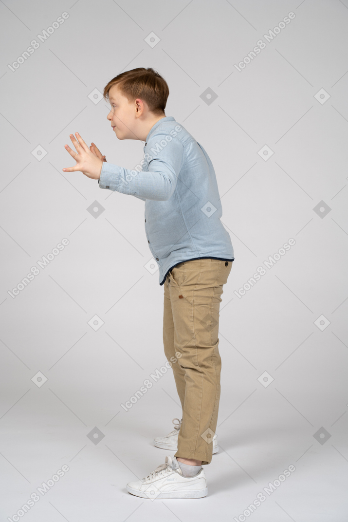Side view of a boy scaring someone
