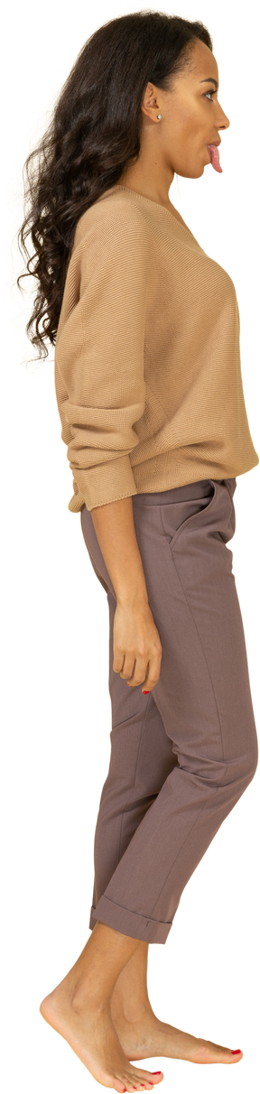 Vista lateral de uma jovem mulher com roupas casuais, mostrando a língua