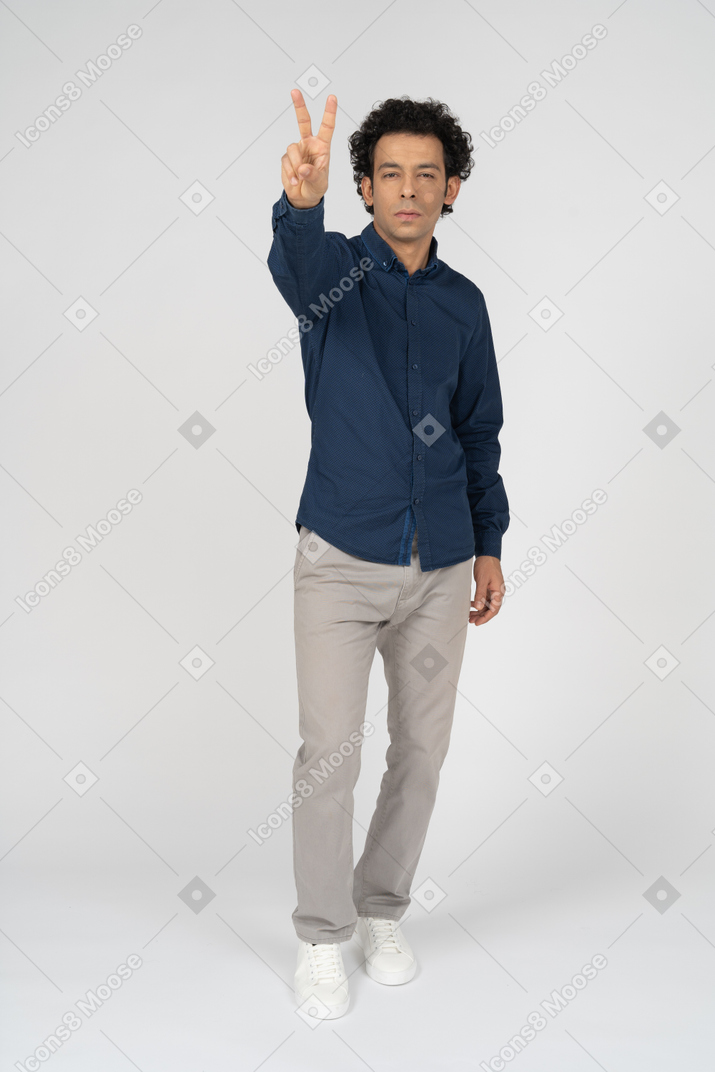 Front view of a man in casual clothes showing v sign