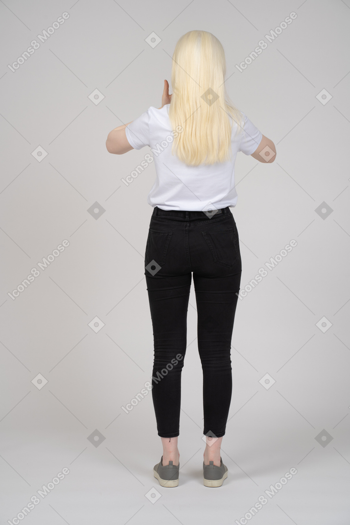 Vista traseira de uma mulher de cabelos compridos em pé