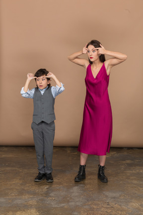 Vista lateral de um menino e uma mulher arregalando os olhos
