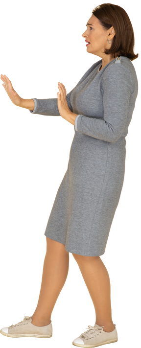Vue latérale d'une femme effrayée en robe grise