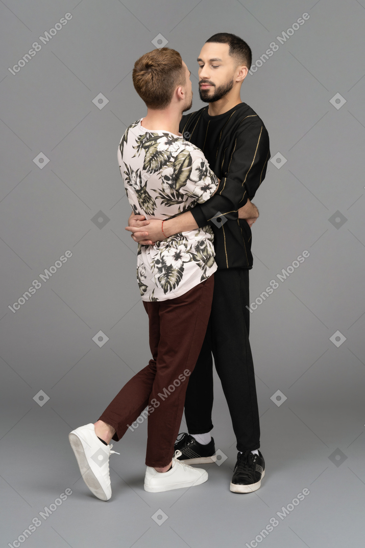 Two young men standing and hugging each other