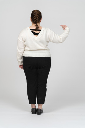 손가락으로 가리키는 흰색 스웨터에 플러스 크기 여자