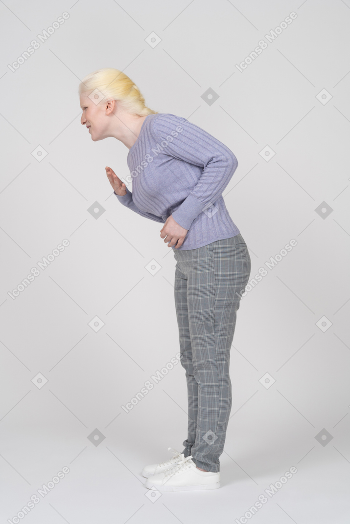 Side view of young woman groaning with stomachache