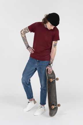 A teenager standing with his skateboard