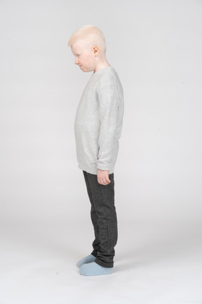 Vista lateral de um garoto garoto descontente apertando os olhos e balançando a cabeça