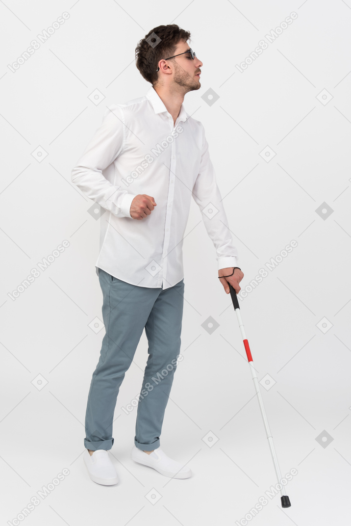 Uomo cieco che usa un bastone bianco