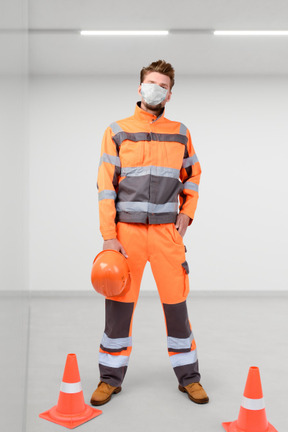 A man wearing an orange safety suit and a mask