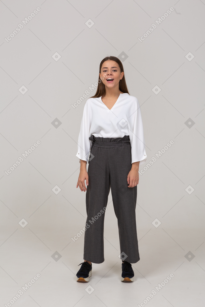 Vista frontal de una joven emocionada en ropa de oficina mirando a la cámara