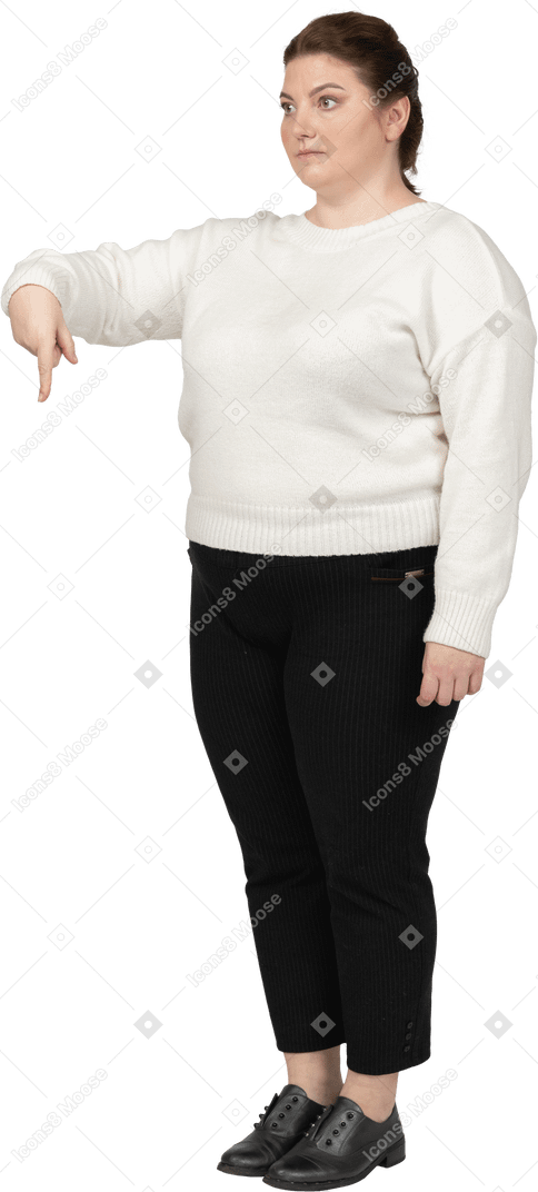 Femme de taille plus dans des vêtements décontractés pointant vers le bas avec un doigt