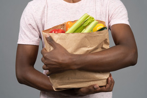 A young man holding a groceries bag