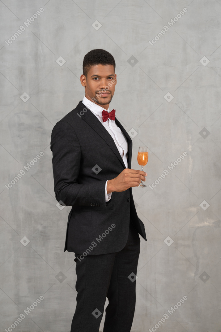 Well-dressed young man holding a champagne glass